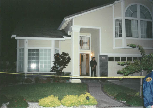 house at night with yellow crime scene tape surrounding it