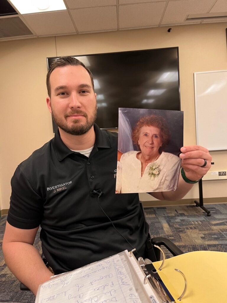 Champlin Police Department Justin Mikel holding a photo of Georgia Smith.