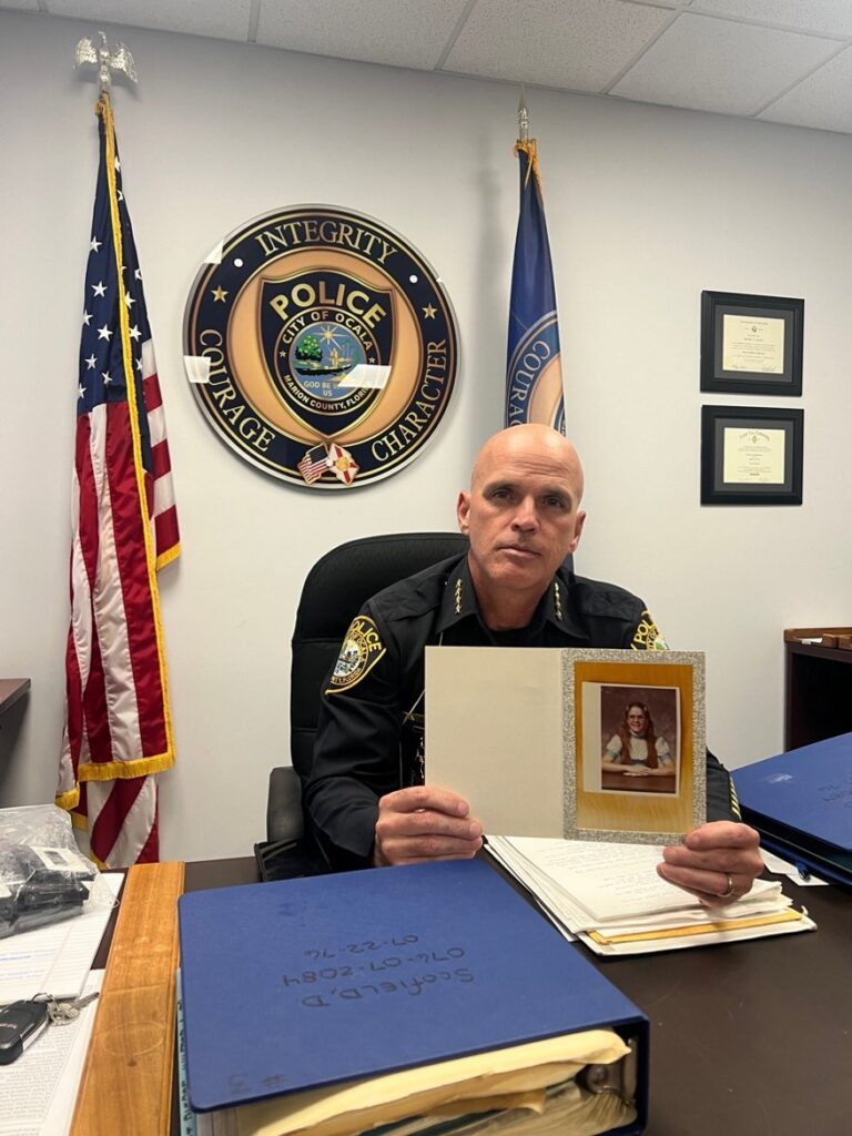 Ocala Police Chief Mike Balken holding a photo of Dee from her case files.