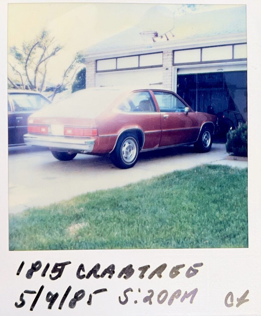 A polaroid photo of Ada’s car in their driveway.