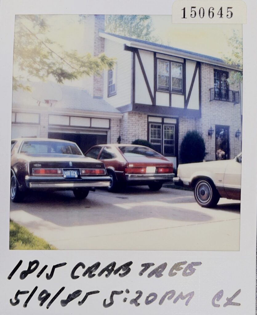 A polaroid photo of the Haradine’s cars in front of their home.