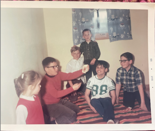 A photo of Bob (second from the left) age 11, performing a card trick for his friends and family. His sister, Amy, is on the left. His childhood friend Randy, who he was going to meet in Baraboo, is second from the right.