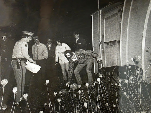 A photo of detectives leading the bloodhound search.