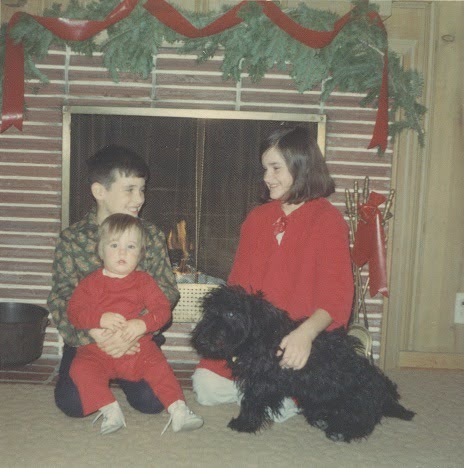 A childhood photo of Lisa with her two brothers, Grant and Tim, and their dog Toofer.