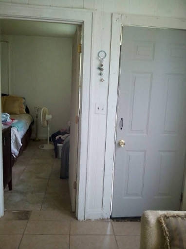 Inside the living room facing the doorway to Luther’s bedroom (left) and the front door (right). This photo was taken in October 2015.
