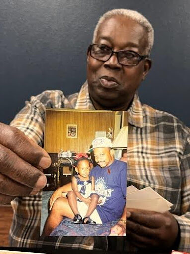 Robert’s brother, Willie Jones Jr., holding up a photo of him.