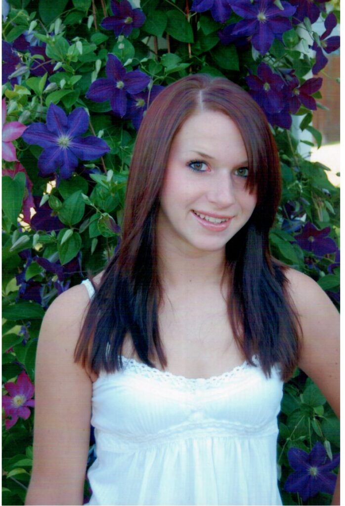 Kelsie, framed by flowers in her favorite color: purple. Courtesy: Laura Saxton.